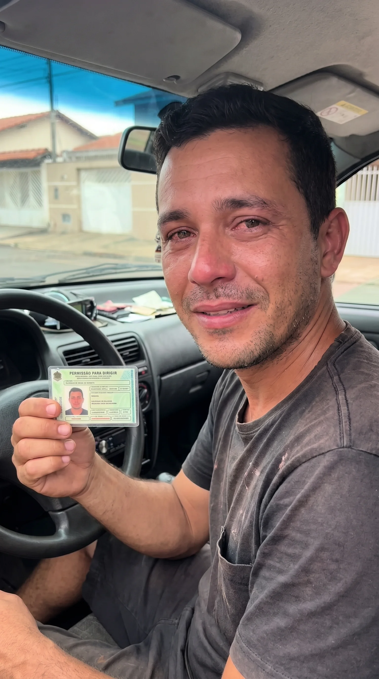 Foto de aluno orgulhoso segurando sua carteira de motorista recém-aprovada através do método do instrutor