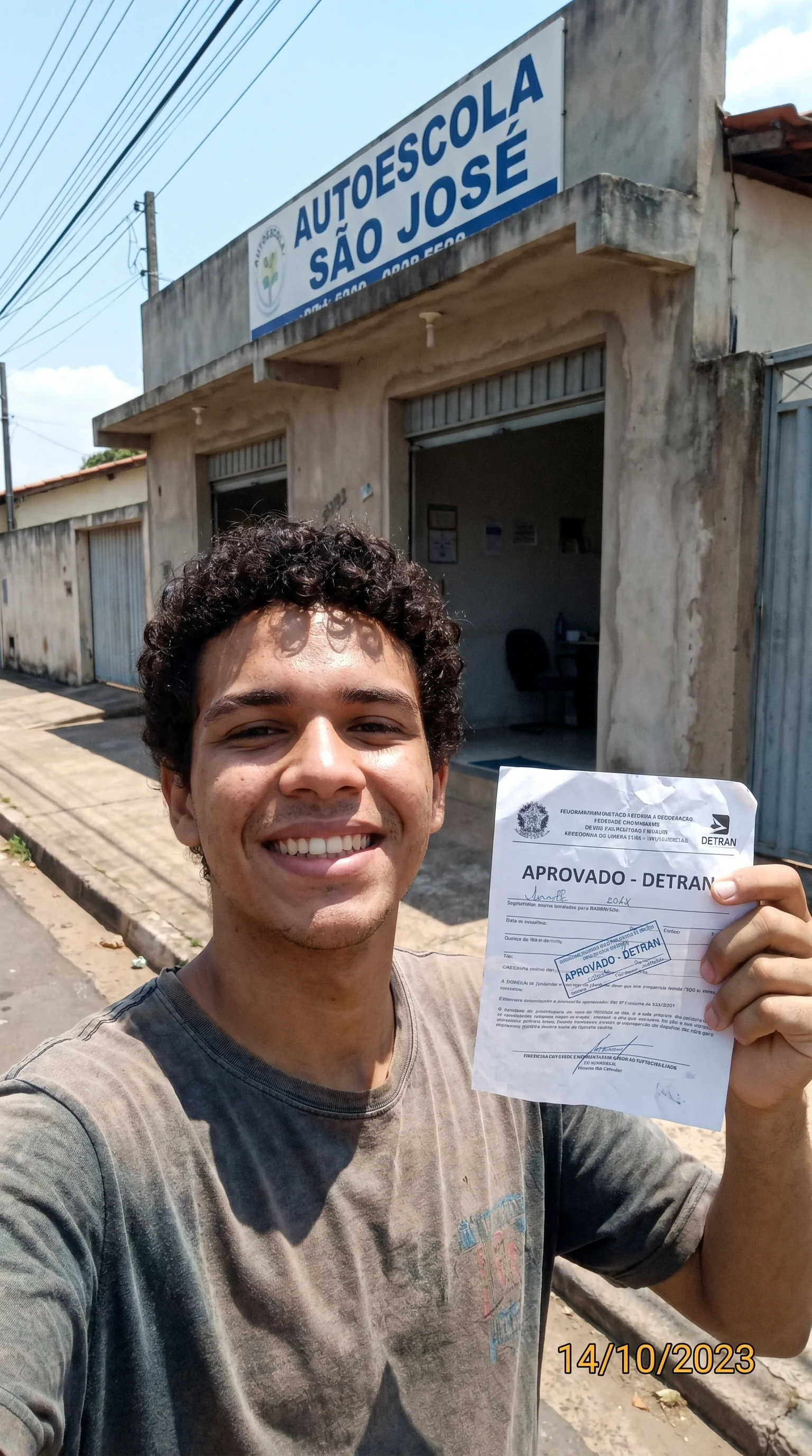 Foto de aluno orgulhoso segurando sua carteira de motorista recém-aprovada através do método do instrutor